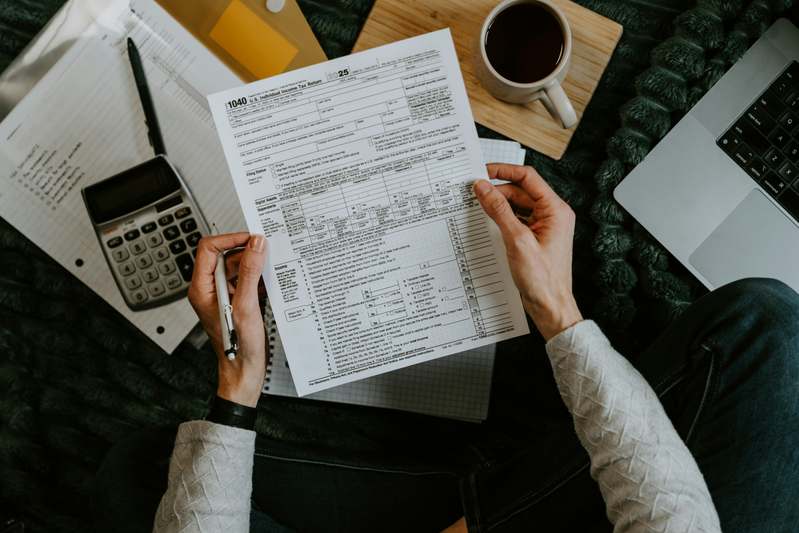 A clean desktop view showing a laptop with IRS Form 8949 open next to a checklist titled 'Crypto Tax Prep Steps' and a notebook labeled '2024 Tax Notes'